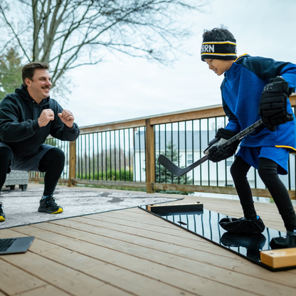 A father and son train using the Brrrn Board and a laptop.