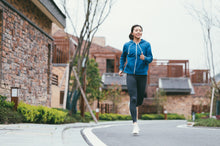 Load image into Gallery viewer, Happy runner in a blue hoodie running down a street
